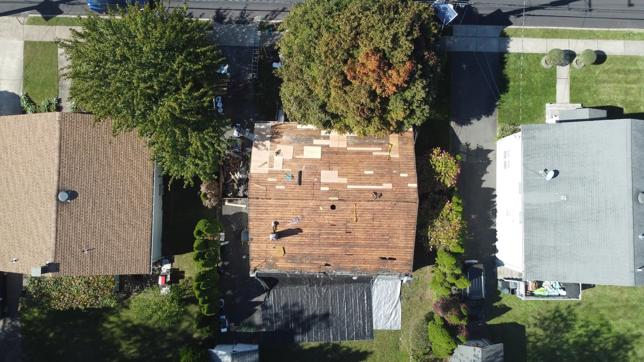 Aerial view of a North Jersey home mid roof replacement with the wood deck exposed