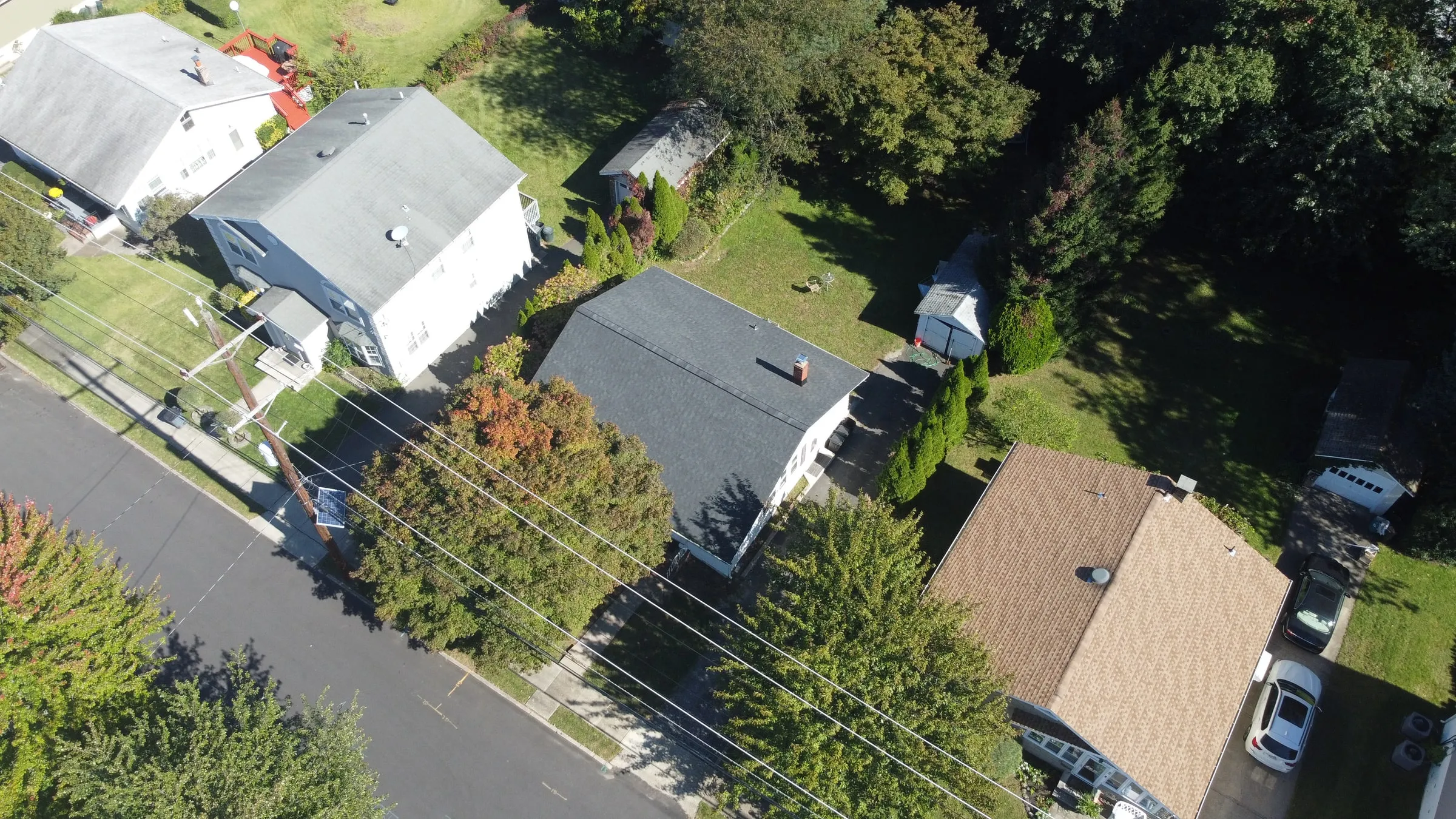 Aerial of a completed roof surrounded by mature trees